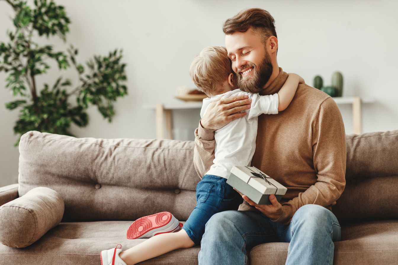 daughter hugging dad after giving him a gift for Father’s Day